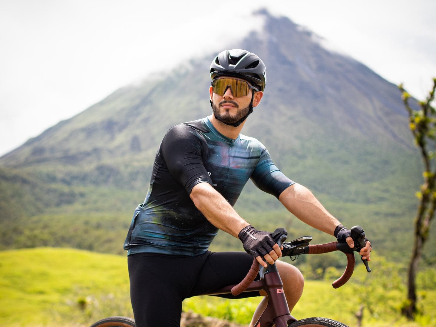 Un ciclista en su bicicleta con el Volcán Arenal detrás