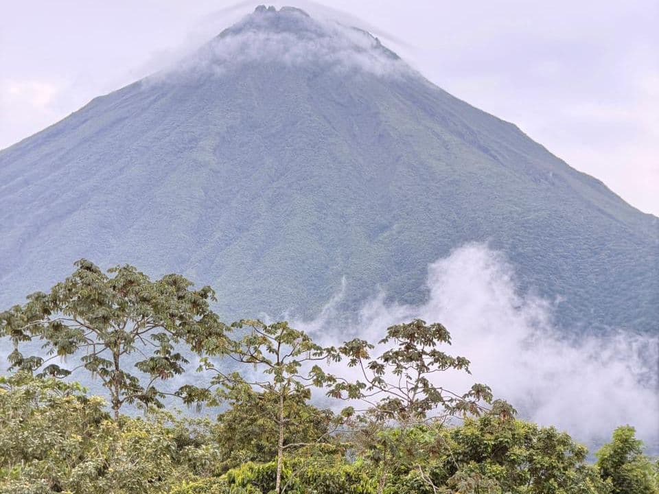 El Volcán Arenal entre nubes, visto desde la propiedad